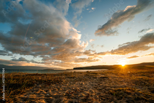 the sandy shore of Lake Baikal at sunset photo