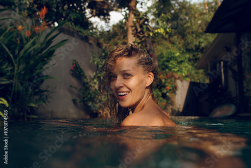 Happy woman swimming in pool on sunny day photo