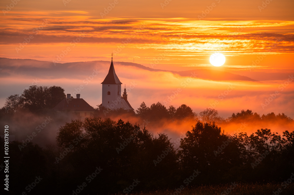 Peaceful Sunrise Over a Rural Christian Church Silhouette Amid Vibrant Autumn Colors and Soft Morning Mist in the Countryside