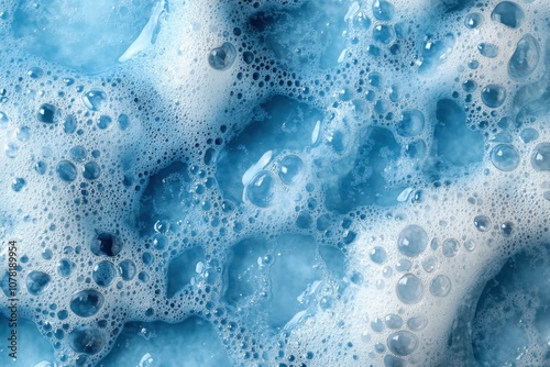 Bubbles and foam create a vibrant blue texture in a close-up view of soapy water