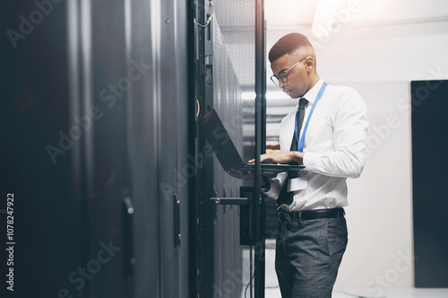 Man, technician and server room with laptop for software, hardware or network repair at office. Male person, IT engineer or fix with computer for technical solution, internet service or system backup