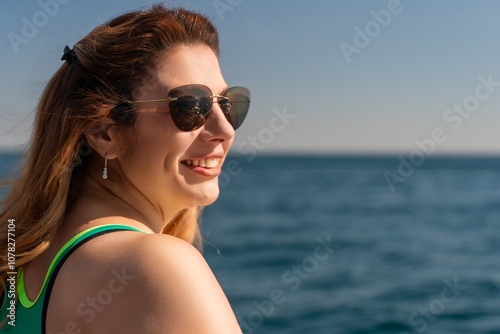 Woman Sunglasses Ocean Smiling - Happy woman wearing sunglasses enjoying the view of the ocean.