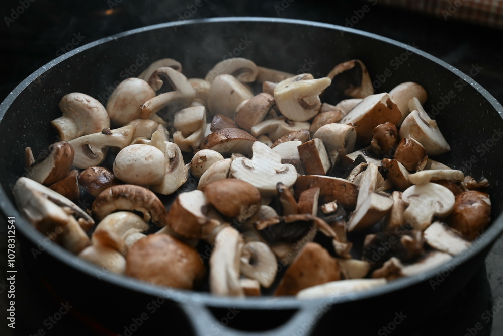 Close up view of sauteed slices of Common Mushrooms (Agaricus bisporus) cooking in the pan Close up view of sauteed slices of Common Mushrooms (Agaricus bisporus) cooking in the pan