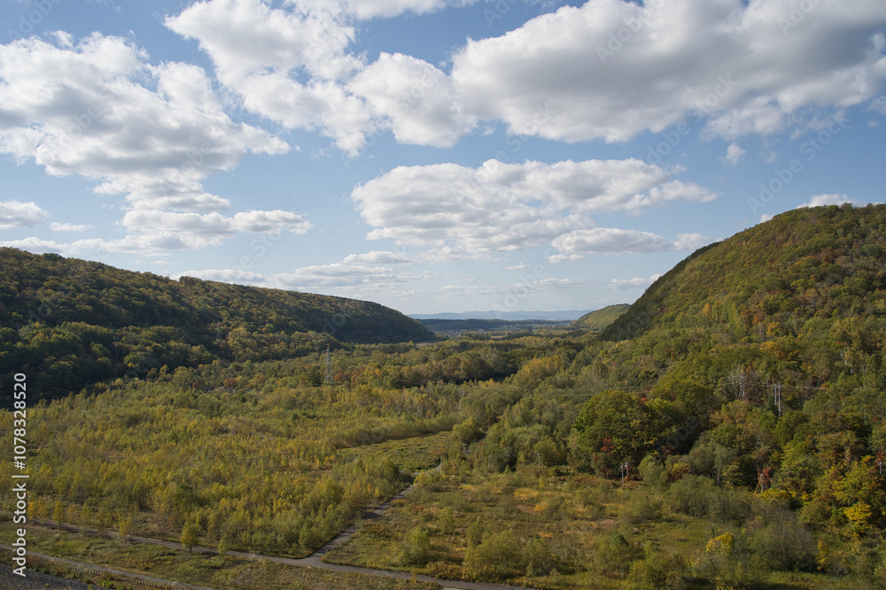 Naklejka premium 北海道旭川市の忠別湖にある忠別ダムの秋の紅葉と夕暮れ時の湖面と青空