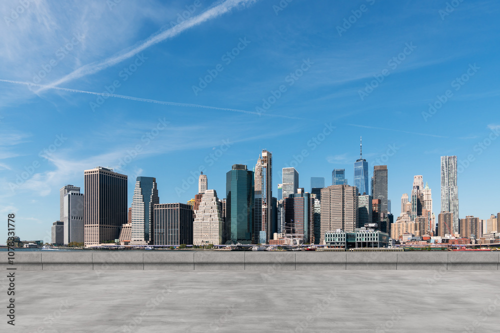 Obraz premium Manhattan skyline view with modern skyscrapers under a clear blue sky.