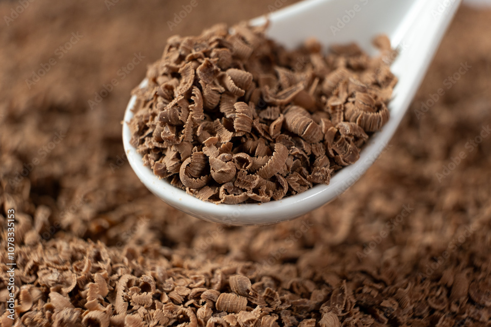 Milk chocolate shavings in a spoon, macro Milk chocolate shavings in a spoon, macro