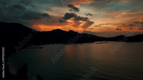 Serene Sunset Over Mountainous Coastline and Calm Waters