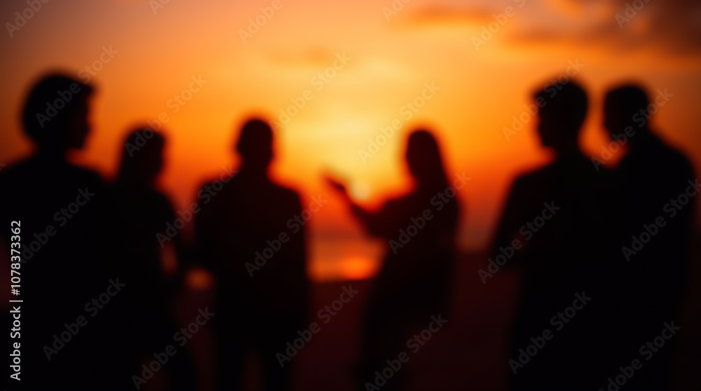 Sunset by the ocean shore with silhouettes of a group of people, friends' meetup, blurred image Sunset by the ocean shore with silhouettes of a group of people, friends' meetup, blurred image