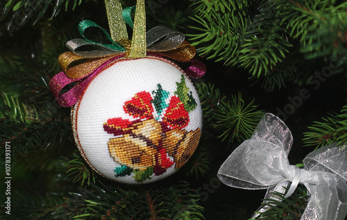 Christmas ball with embroidered bells hanging on the tree  