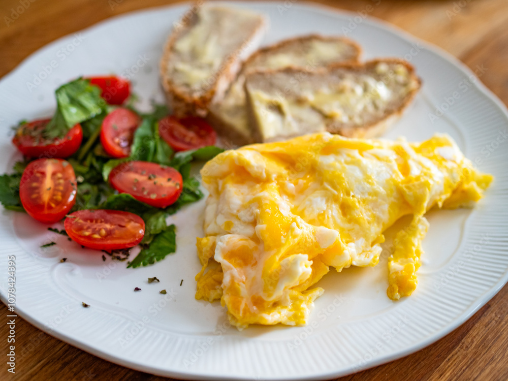 Continental breakfast - scrambled eggs, slice of bread with butter and fresh vegetables on wooden table
Continental breakfast - scrambled eggs, slice of bread with butter and fresh vegetables on wooden table