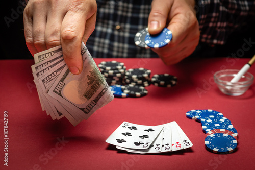 A gambler bets on a winning combination of cards full house or full boat in a casino. A successful poker game with a huge win and chips on the red table photo