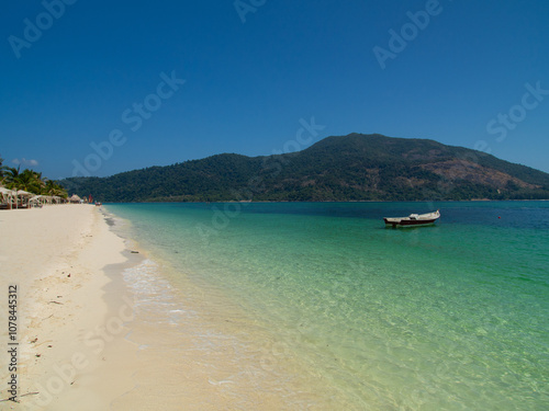 Pristine Beach with Clear Turquoise Waters and Boat on Koh Lipe, Thailand photo