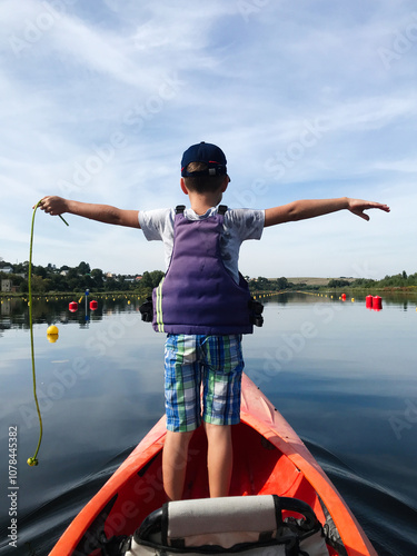 Young boy kayaking on a calm lake on a sunny day