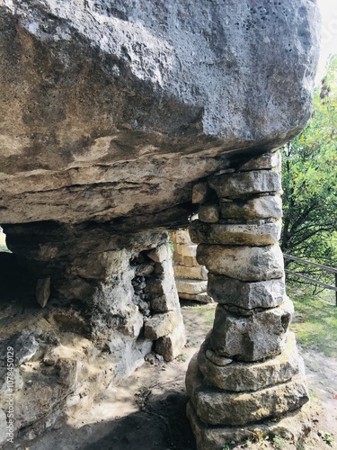 Ancient stone structure surrounded by lush greenery and sunlight photo