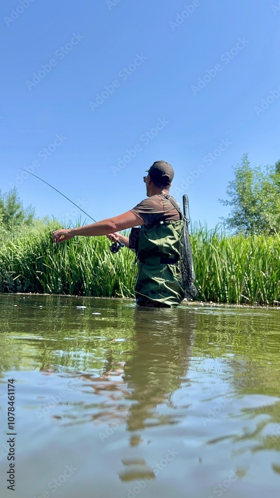 Fisherman casting line in a river on a clear summer day Fisherman casting line in a river on a clear summer day