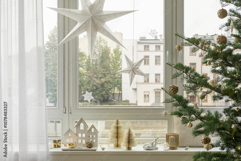 Christmas window decor with star lanterns, festive ornaments, and a pine tree. Cozy and bright holiday home setup. Christmas window decor with star lanterns, festive ornaments, and a pine tree. Cozy and bright holiday home setup.