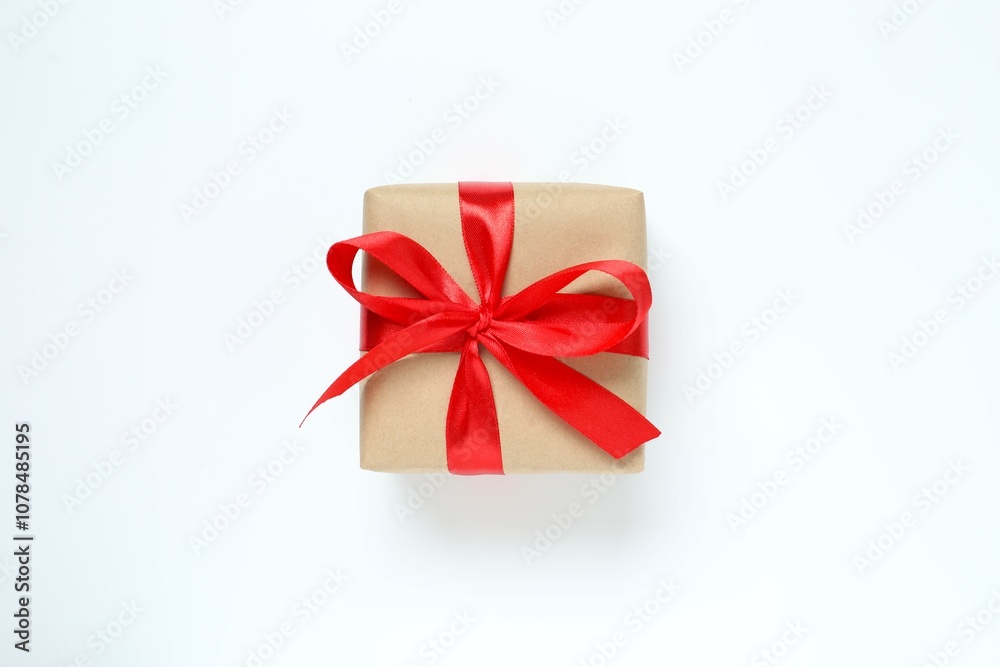Beautiful gift box tied with golden bow on color background Beautiful gift box tied with golden bow on color background