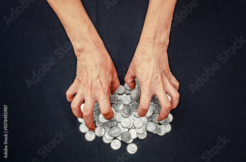 Fényképezés Top view of greedy hands reaching fo pile of silver coins