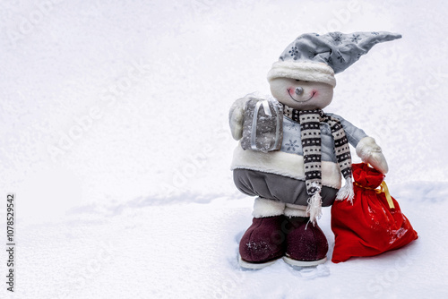 Puppet snowman with bag of presents standing on snow, closeup of toy with space for text. photo