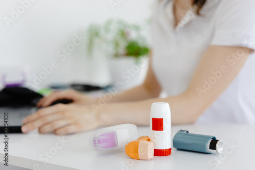 Doctor writes at laptop medical prescription for asthma inhaler to asthmatic patient during medical consultation and examination in clinic