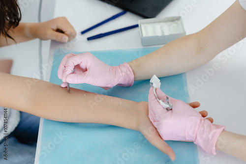 Doctor doing skin allergy test at white table in office. Allergy test - skin prick allergy testing for possible allergens photo