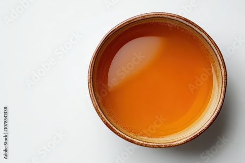 A bowl of orange liquid. This photo is ideal for illustrating recipes, articles, or blogs related to food, beverages, or cooking.