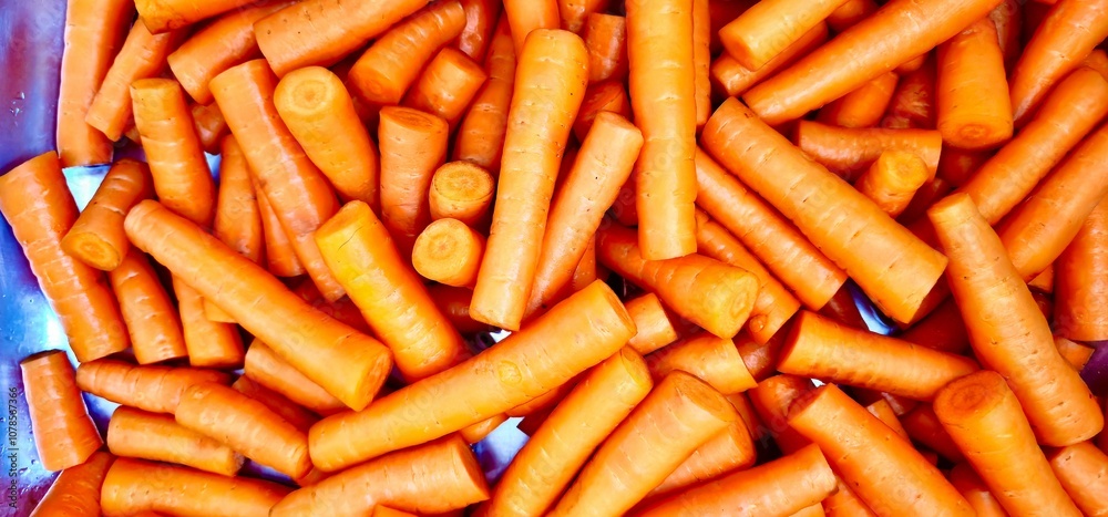 Closeup of raw carrots being cleaned and trimmed in a kitchen basin Closeup of raw carrots being cleaned and trimmed in a kitchen basin