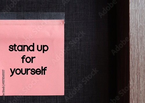Fotografie Pink note on dark copy space background written Stand up for yourself - assertiv