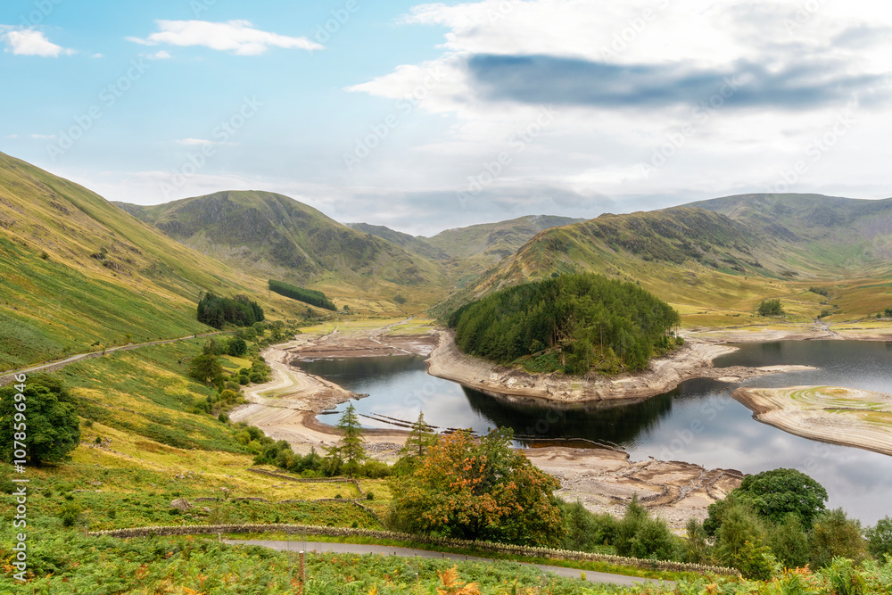 Naklejka premium Stunning landscape view of a serene lake surrounded by rolling hills in the countryside during a clear day