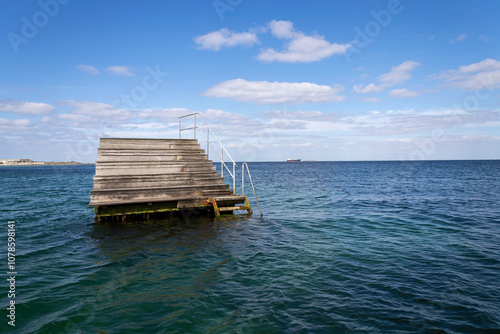 Empty wooden pier for swimming and hardening in the sea, Copenhagen, Denmark, sunny day, blue sky copy space photo