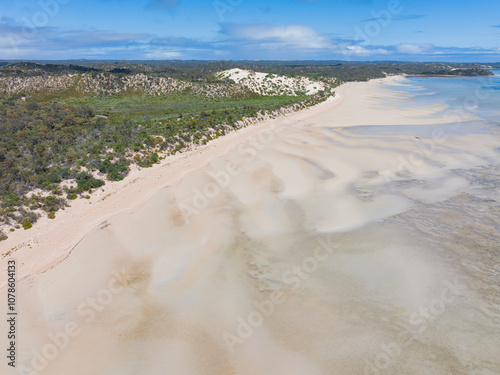 Aerial view of patterns on tidal sand flats along a wide coastal shoreline photo