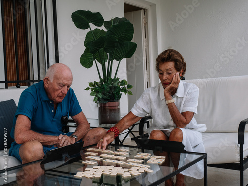Marriage octogenarian play animatedly to a board game consisting of making combinations of numbers