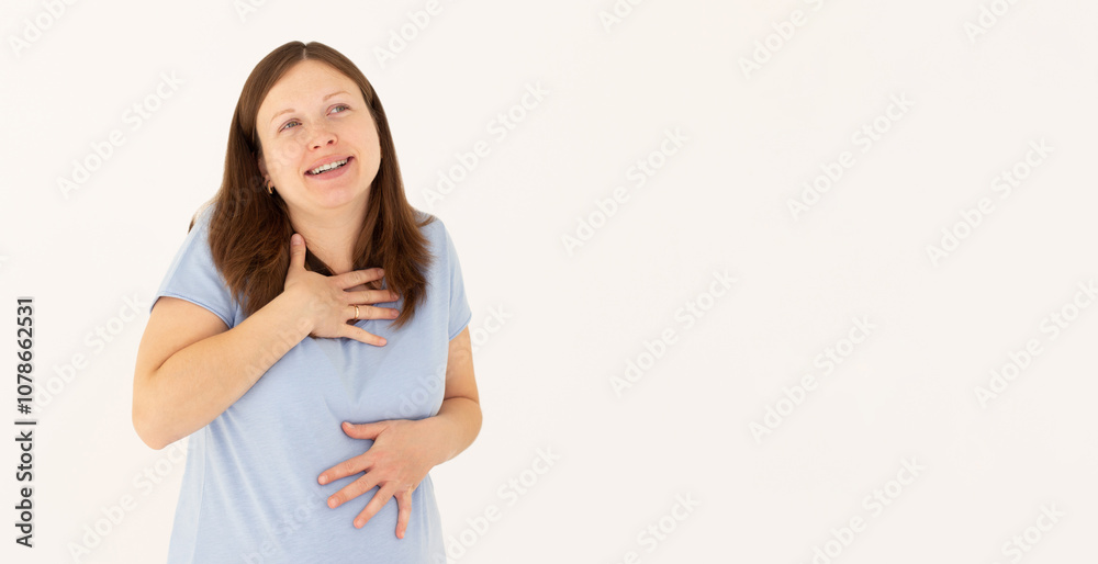 Portrait of extremely happy girl in blue t-shirt holding her stomach and chest and laughing out loud, chuckling giggling at amusing anecdote, sincere emotion. isolated on white background Portrait of extremely happy girl in blue t-shirt holding her stomach and chest and laughing out loud, chuckling giggling at amusing anecdote, sincere emotion. isolated on white background