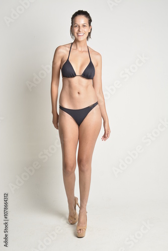 short hair, natural, no makeup, woman, white t-shirt, black pants, blue swimsuit, bikini, skates, casual, authentic, lifestyle, candid, minimal, female model, simplicity, everyday look, relaxed, comfo