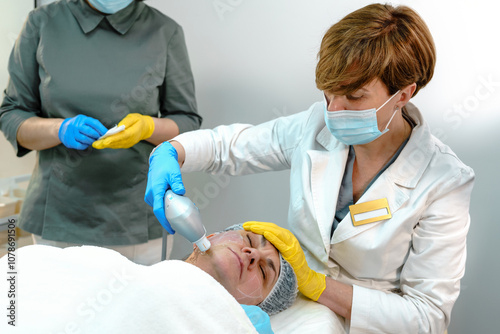 Medical Professionals Performing Facial Skin Treatment photo