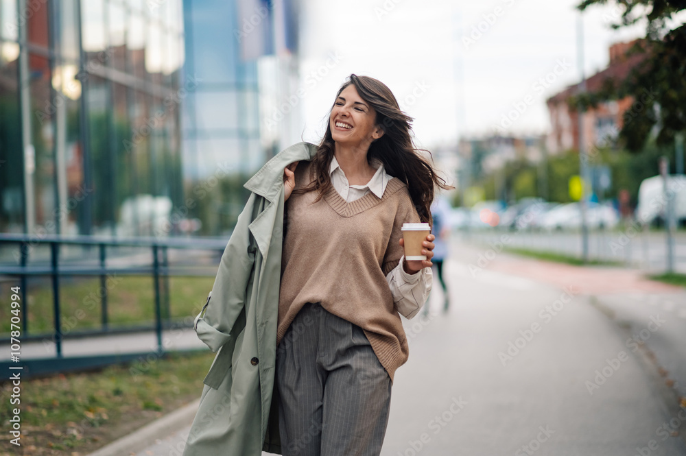 Fototapeta premium Happy stylish woman walking in the city with coffee