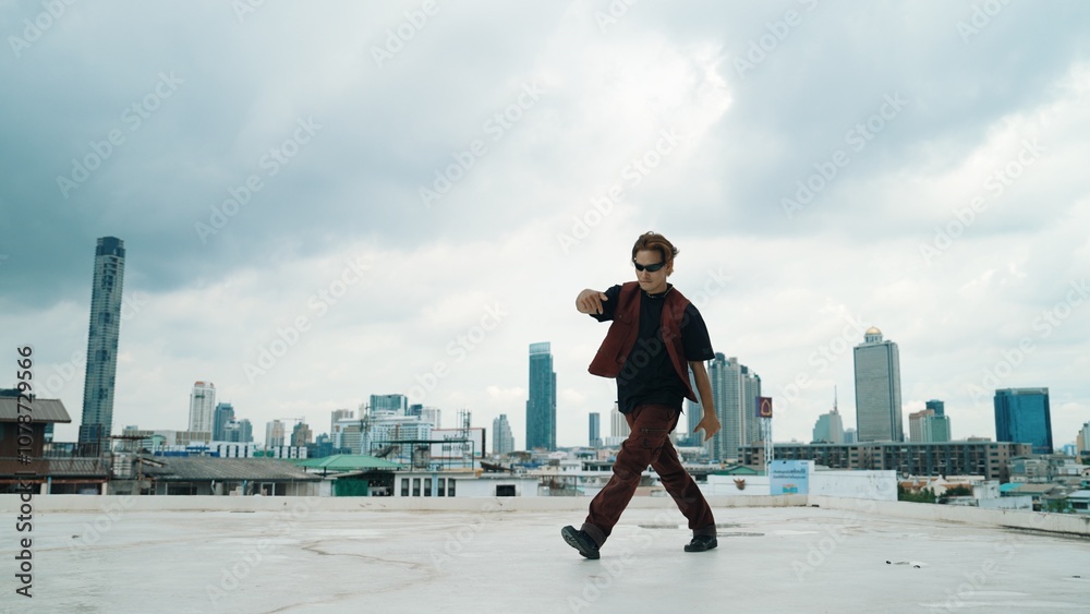 Motion shot of B-boy dance performance by professional street dancer at rooftop with sky scrapper, city view. Attractive asian hipster show energetic footstep. Outdoor sport 2024. Hiphop. Motion shot of B-boy dance performance by professional street dancer at rooftop with sky scrapper, city view. Attractive asian hipster show energetic footstep. Outdoor sport 2024. Hiphop.