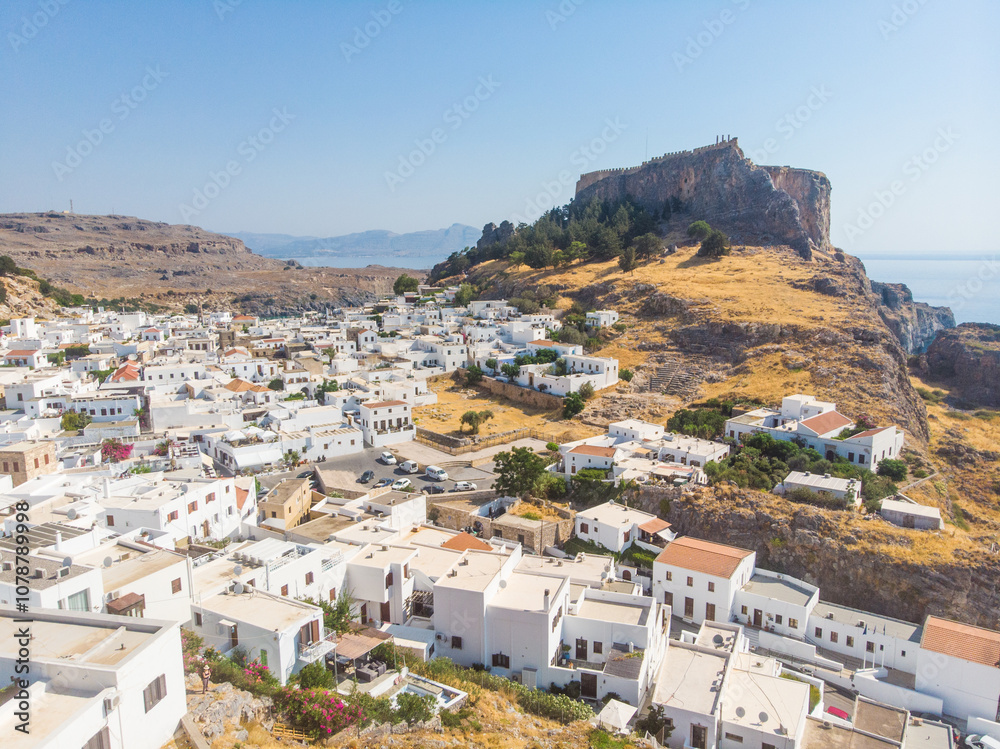Aerial view of Lindos, Rhodes - a little old white Greek town on the Mediterranean coast to the foothills of the Acropolis if Lindos Aerial view of Lindos, Rhodes - a little old white Greek town on the Mediterranean coast to the foothills of the Acropolis if Lindos
