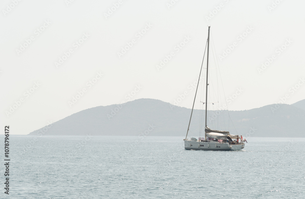 Sailboat with mast and open sails is sailing on a calm sea. Greek Islands, Ionian Sea Sailboat with mast and open sails is sailing on a calm sea. Greek Islands, Ionian Sea