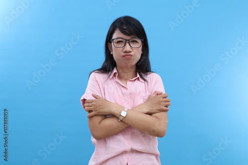 Unhappy young girl feels lonely and cold, looks sadly at camera, keeps hands crossed, being dejected by bad weather, gloomy day, expresses negative feelings. Mood, season