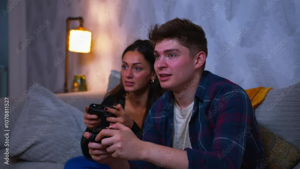 Cute couple playing video games on the sofa together and lose the game