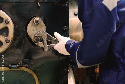 A man is fixing a machine with a wrench. Concept of determination and focus as the man works to repair the machine