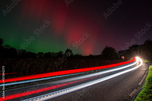 traffic at night with northern lights in background