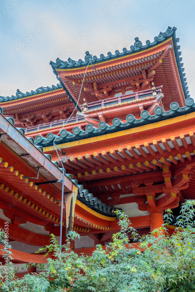 Fototapeta premium Ornate rooftops of kiyomizu-dera temple rising above lush greenery in kyoto
