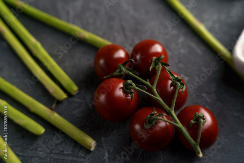 a branch of cherry tomatoes on a dark background