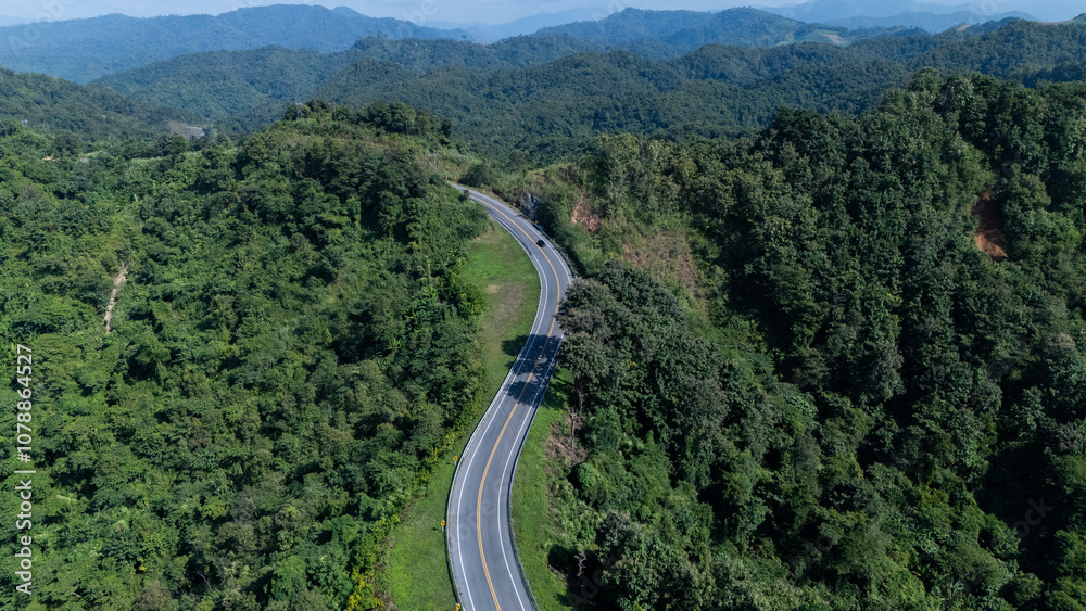 Road number three, Nan Province, aerial view of a beautiful road through the mountains full of green trees. Travel concept, transportation concept. Road number three, Nan Province, aerial view of a beautiful road through the mountains full of green trees. Travel concept, transportation concept.