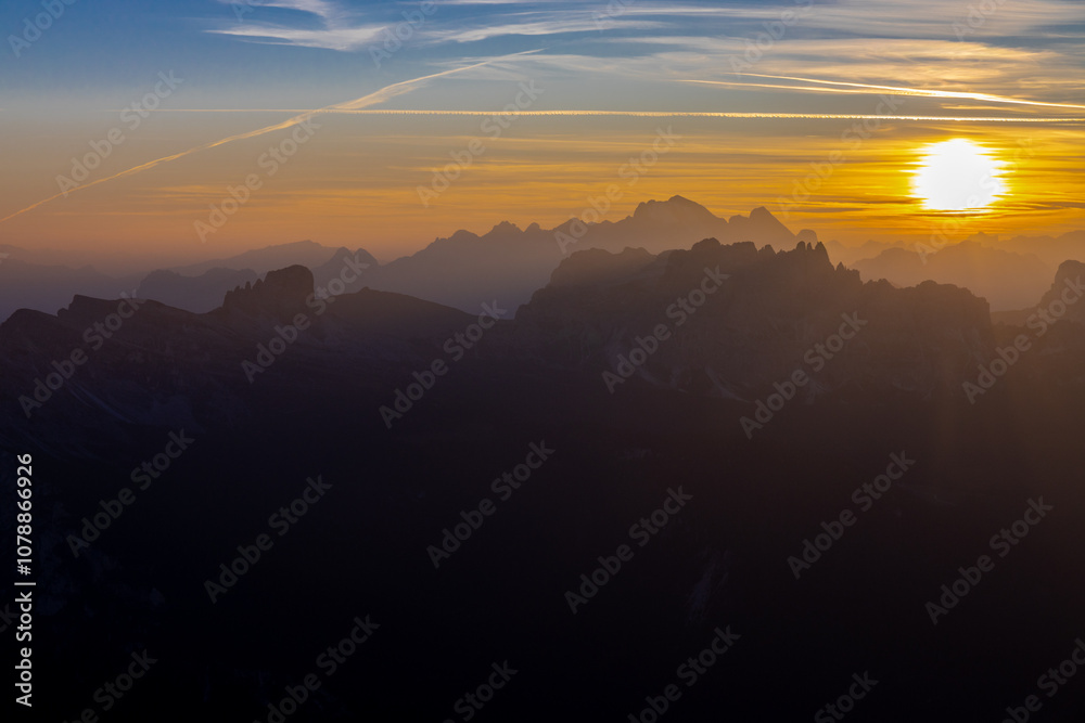 Obraz premium Sunset in the Dolomites beautiful landscape with mountain silhouettes and burning red light sky on the background. Sunrise and sunset in the Doloiti Alps