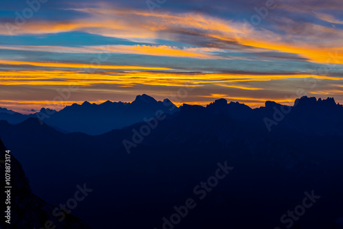 Sunset in the Dolomites beautiful landscape with mountain silhouettes and burning red light sky on the background. Sunrise and sunset in the Doloiti Alps