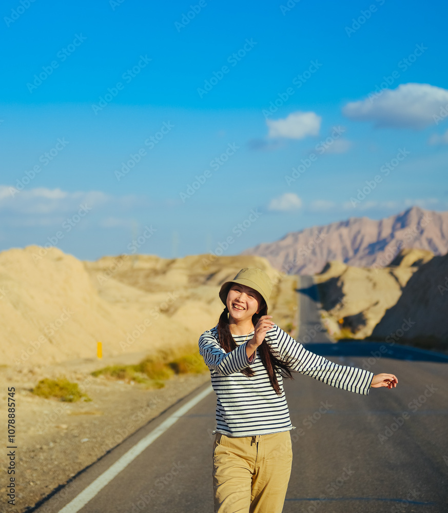 Naklejka premium Asian woman walks towards the viewer on Duku Highway (Rd. G217) at Aksu, Xinjiang, China
