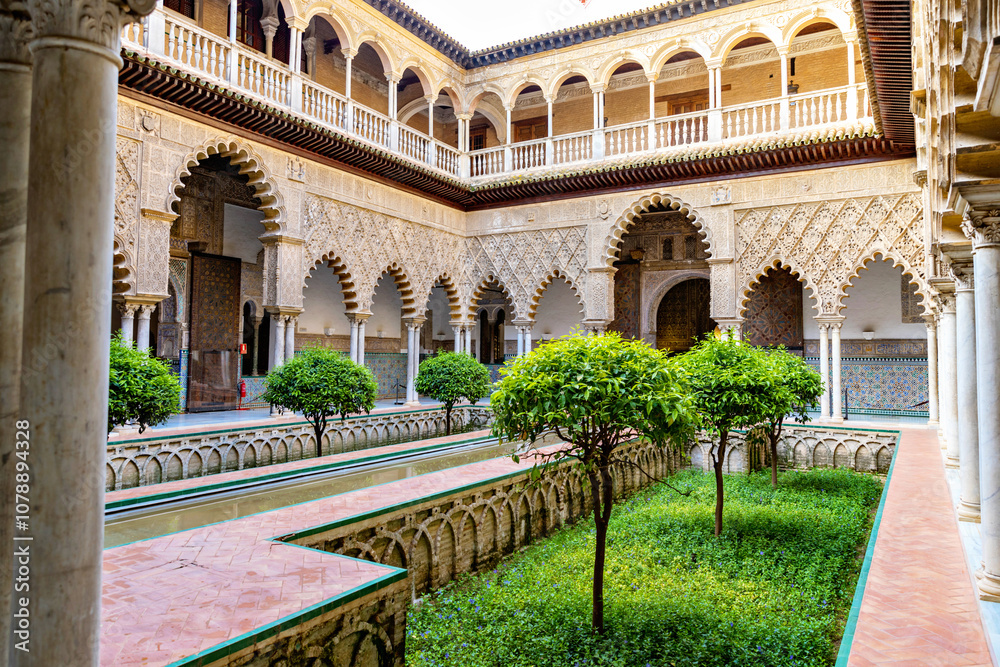 Obraz premium Beautiful formal public garden inside Alcazar Seville palace in summertime in Andalusia